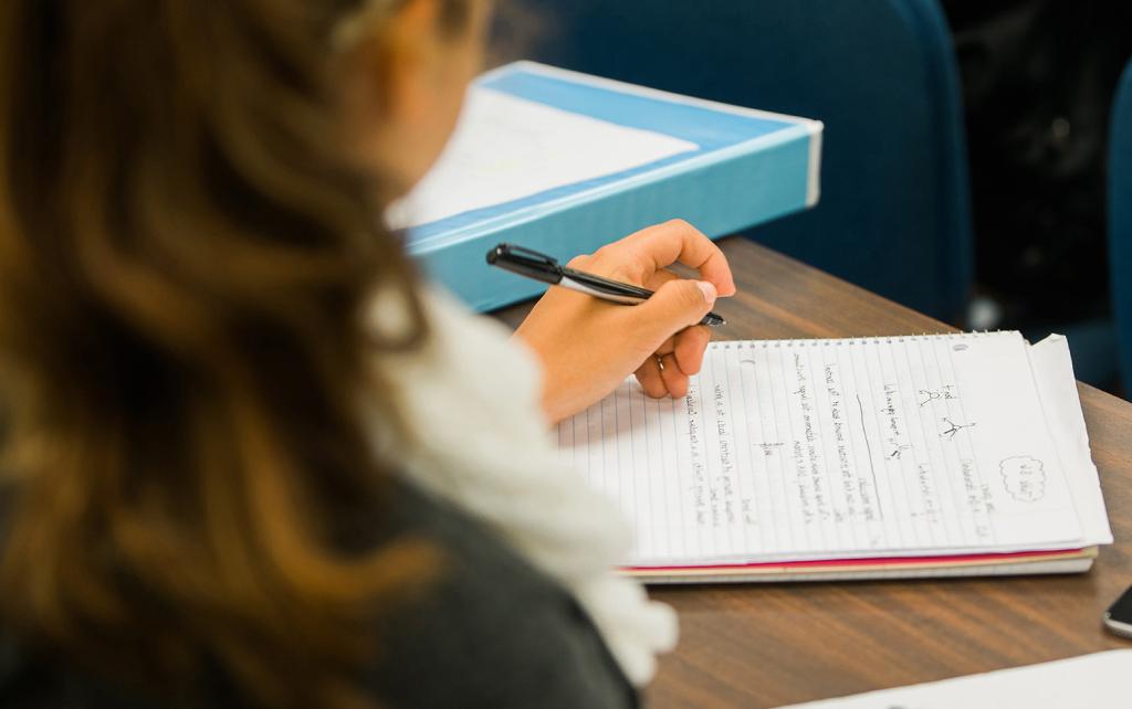 Student studying at a desk with a notebook